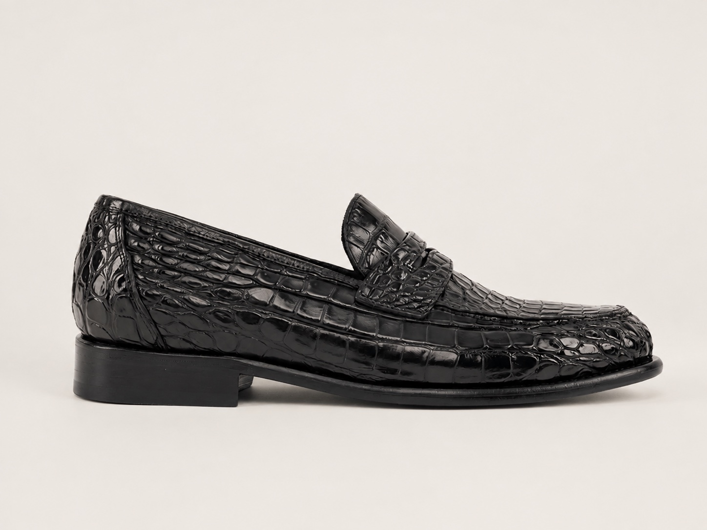 Side profile of the black crocodile penny loafer