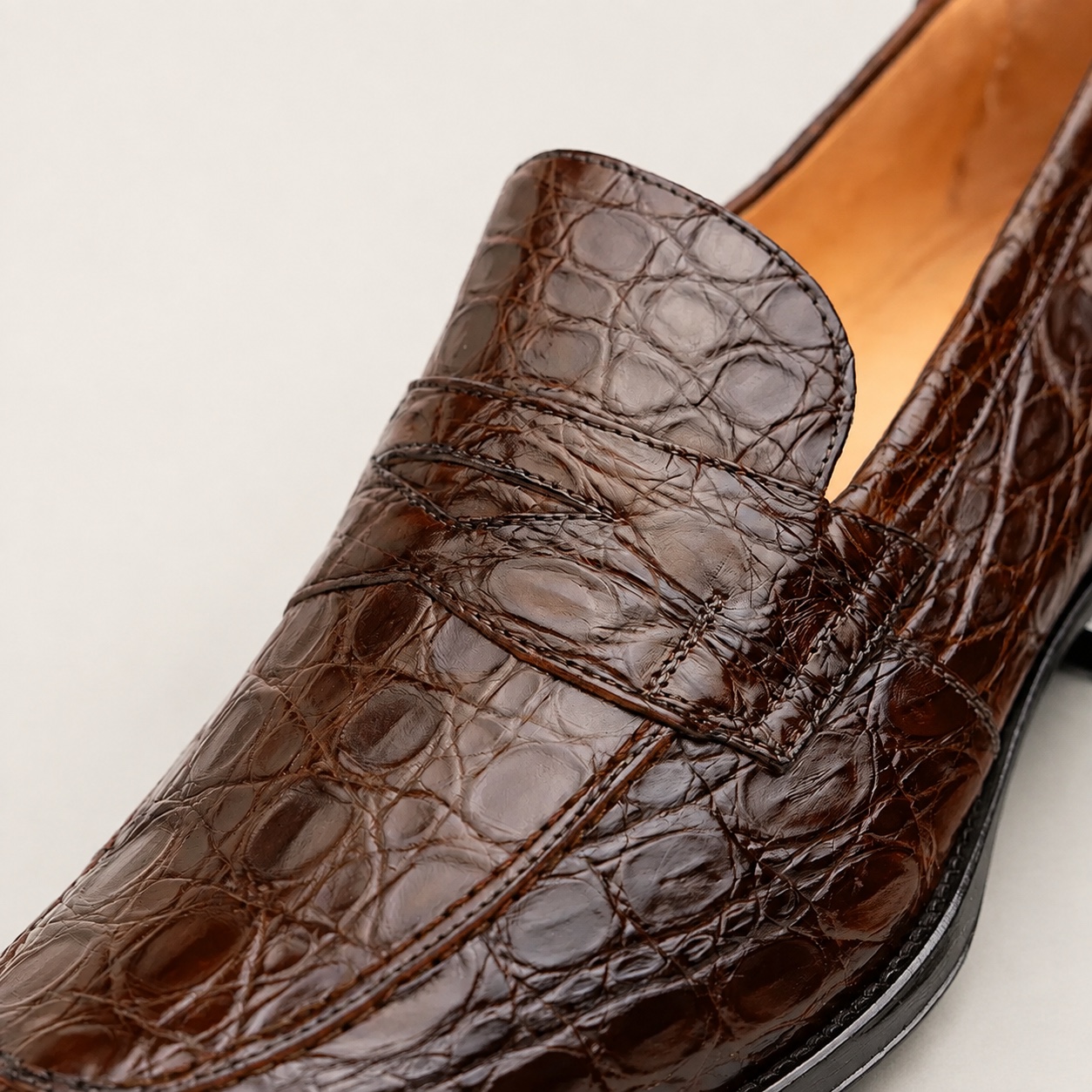 Cognac crocodile penny loafer strap and stitching detail