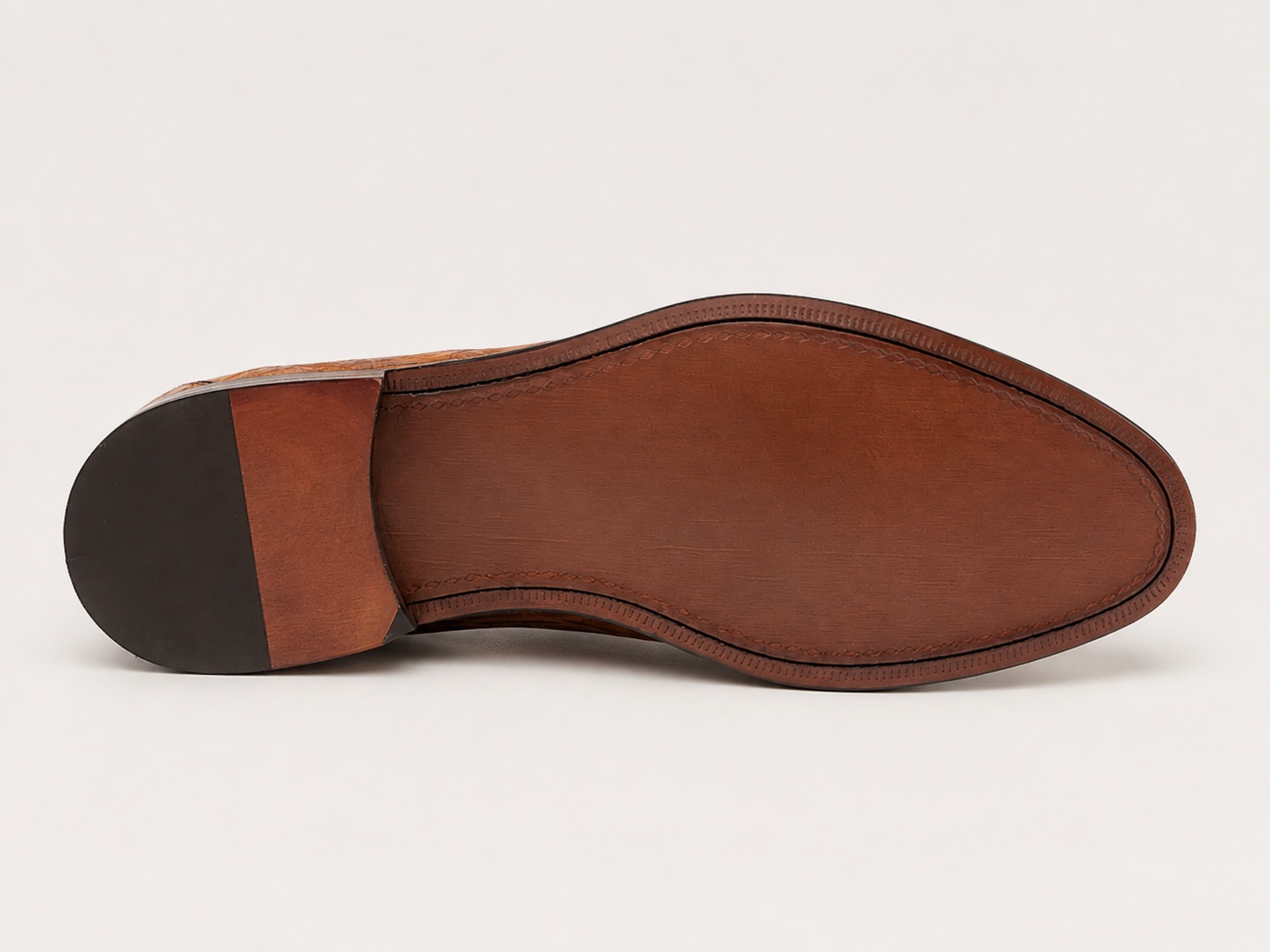 Brown outsole view with dark heel wear patch and identifying marks removed