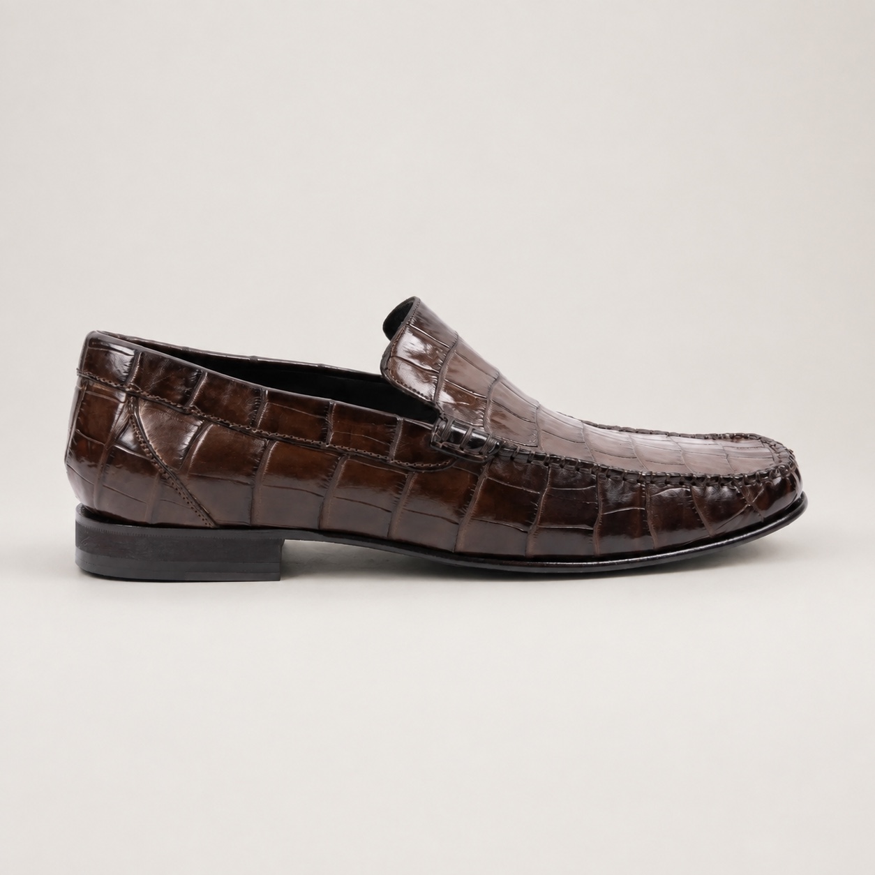 Side profile of a dark brown crocodile slip-on loafer
