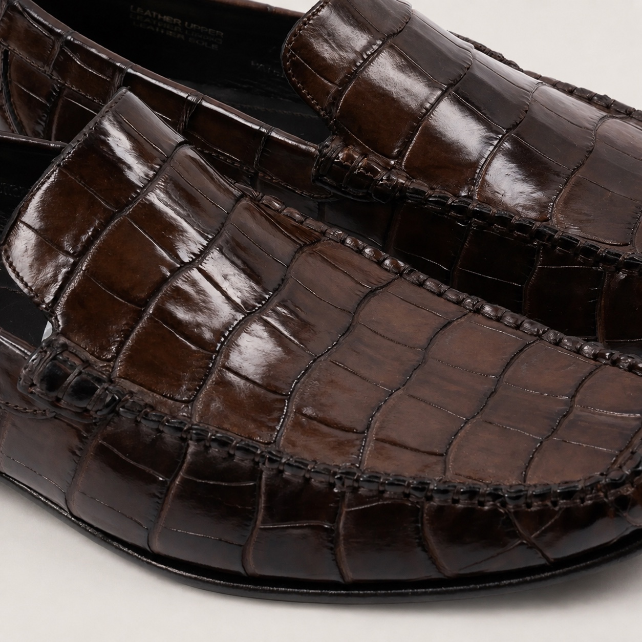 Close-up of the dark brown crocodile leather vamp and apron stitching