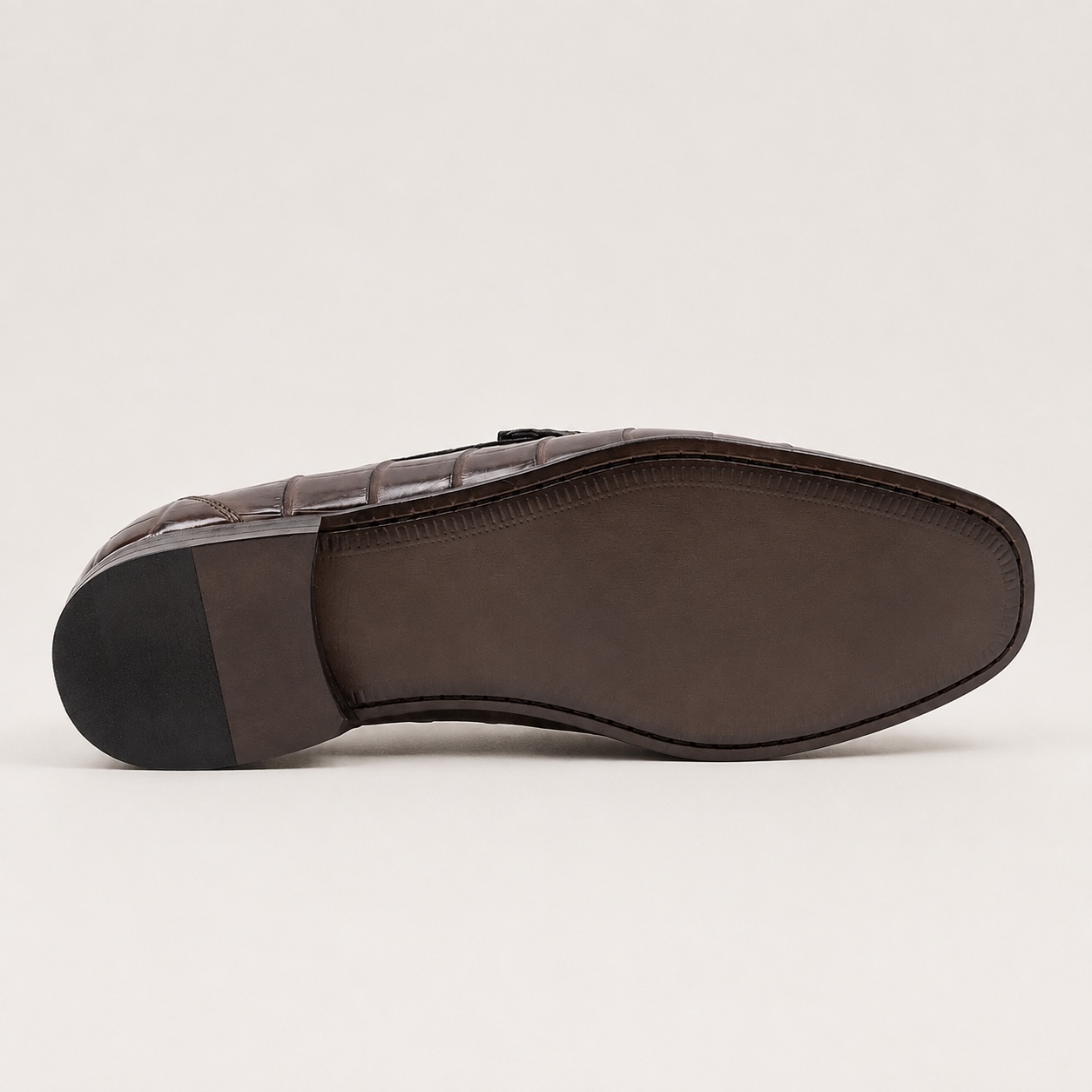 Underside of the dark brown crocodile loafer with identifying marks removed