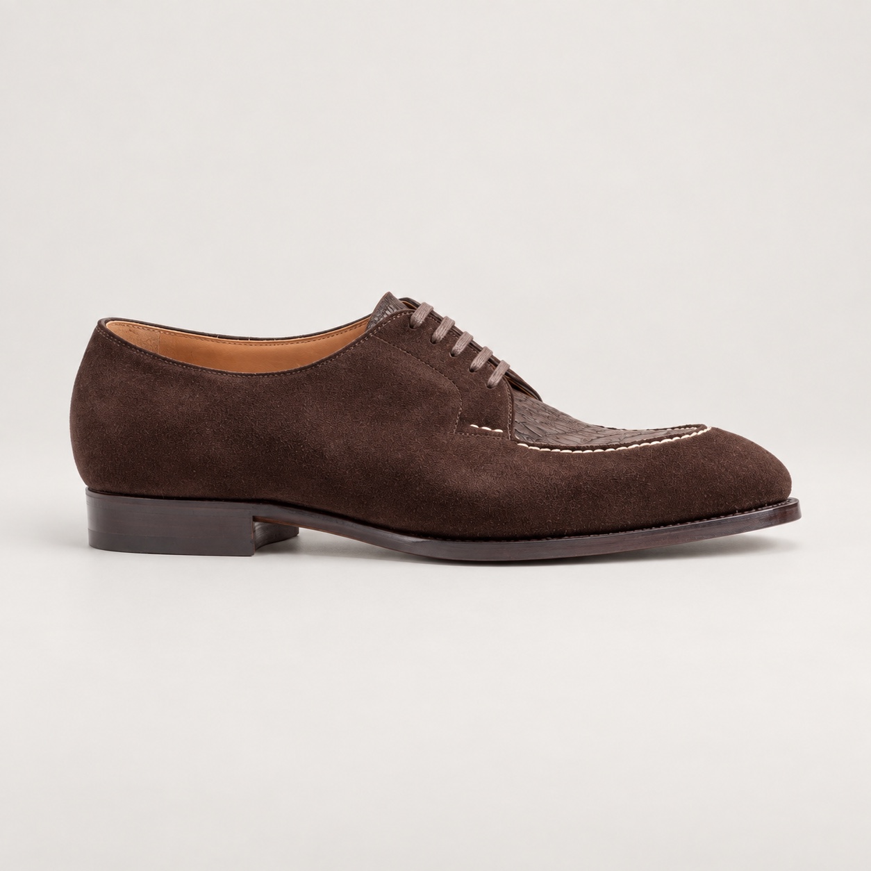 Side view of the espresso brown lace-up shoe with contrasting suede-textured panels