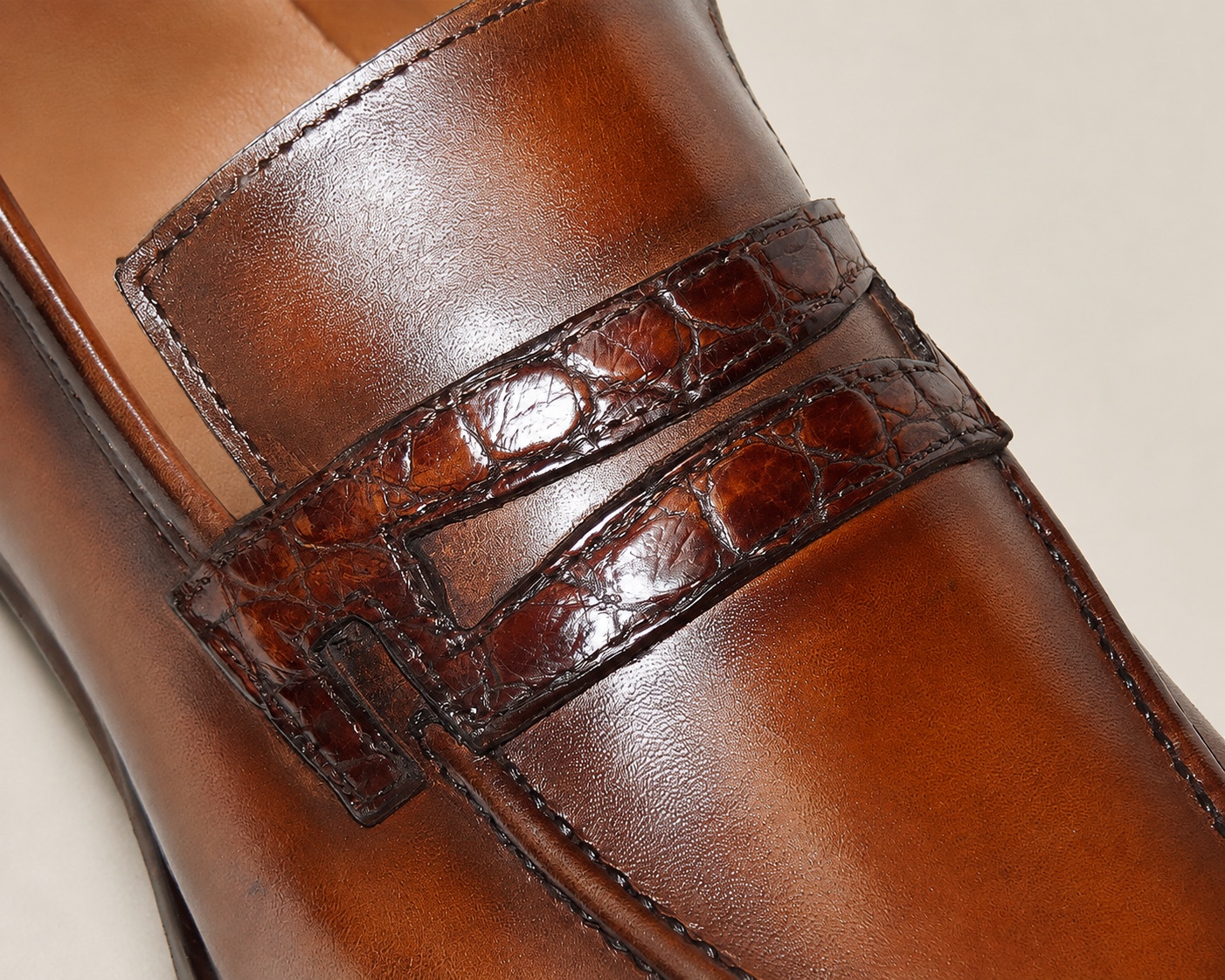 Close-up of the alligator penny strap against the smooth hand-painted brown cowhide upper