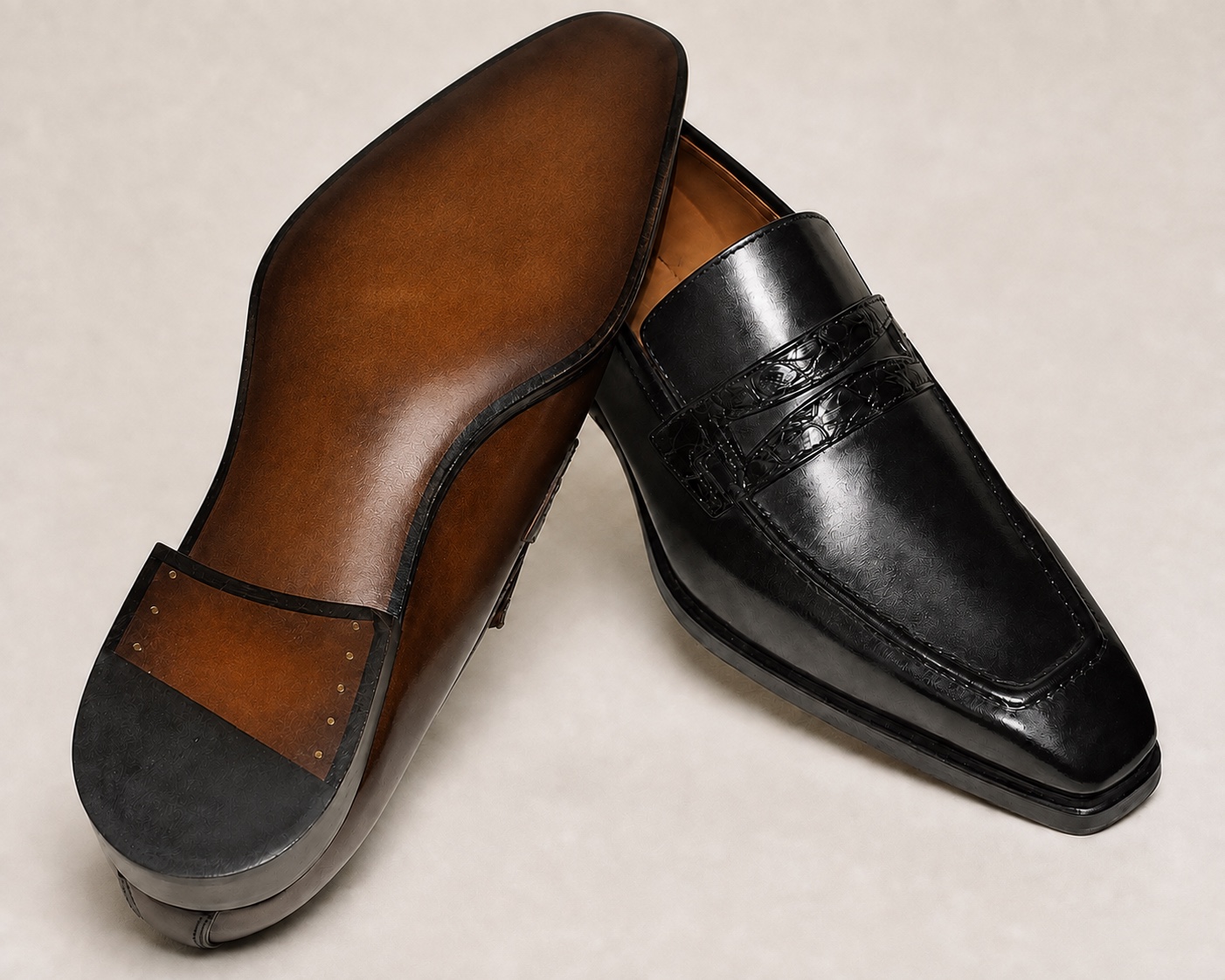 Digitally shown brown patina outsole beside the black loafer, with identifying marks removed
