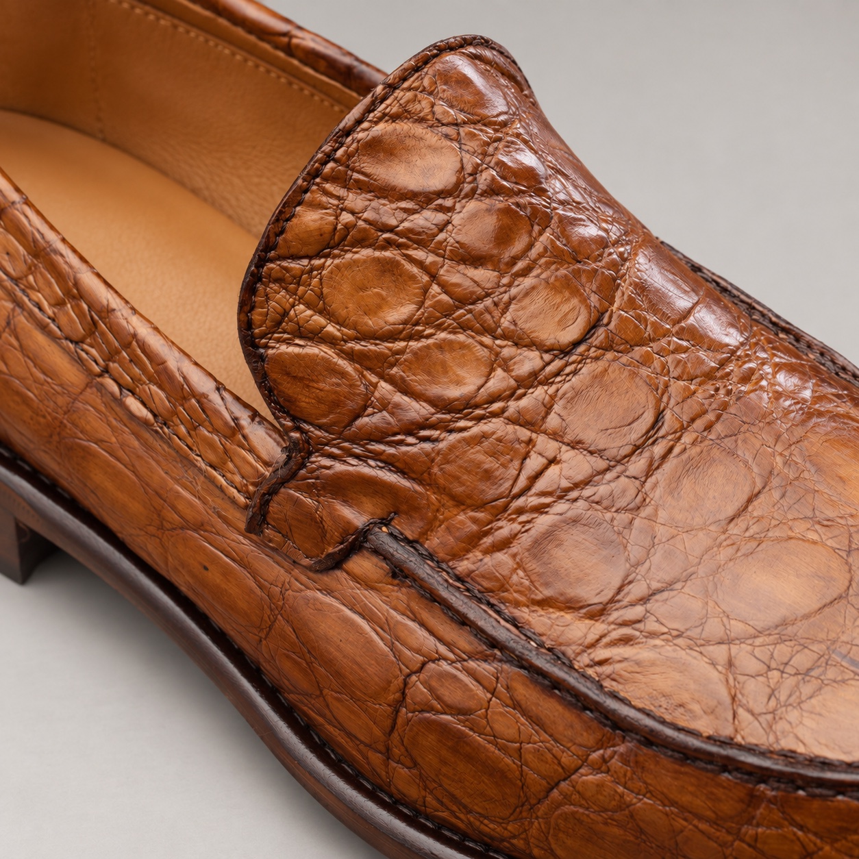 Close-up of the alligator leather texture, apron stitching and unbranded cowhide lining