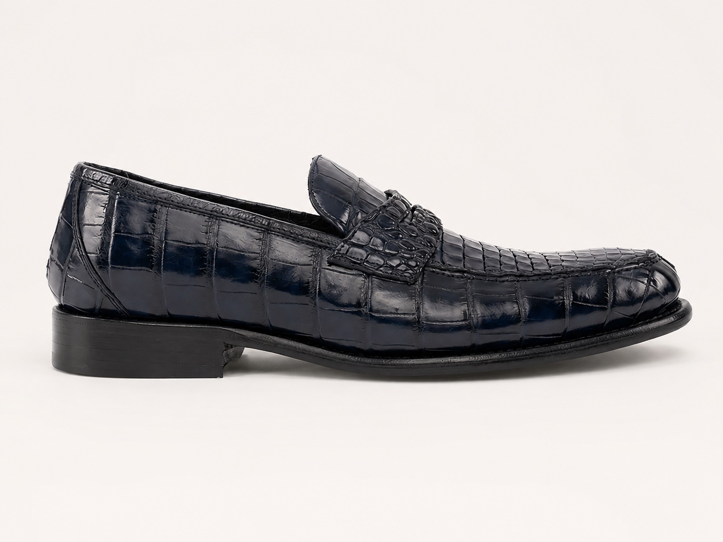 Side profile of the navy blue crocodile penny loafer