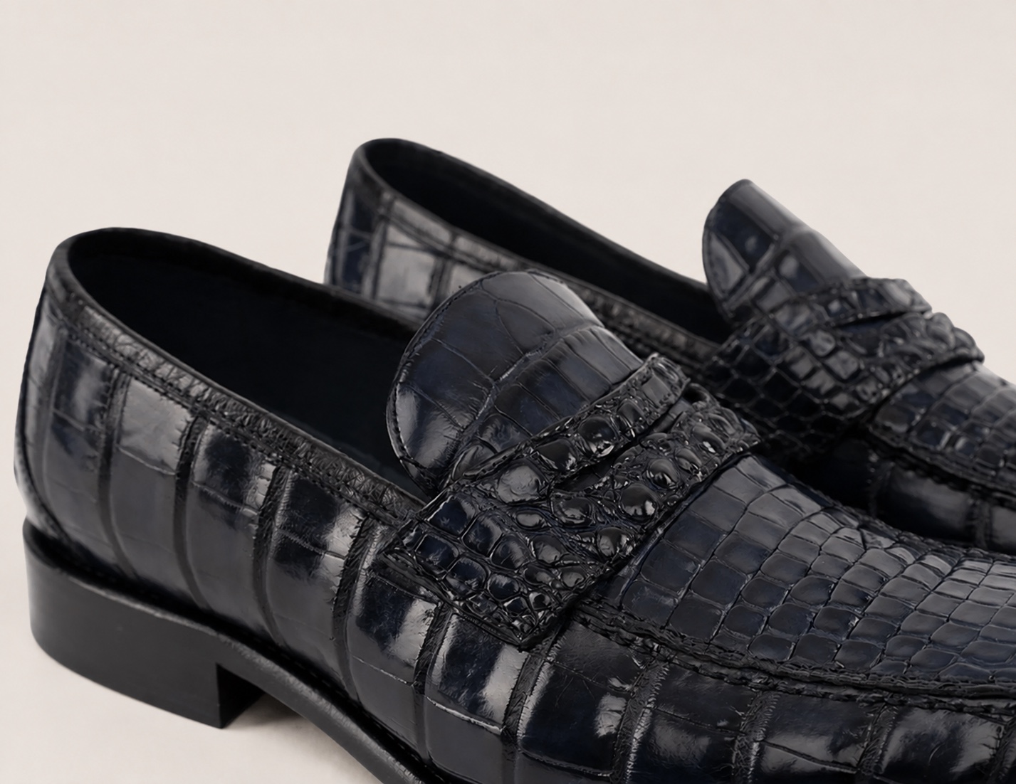 Navy blue crocodile penny strap, side-panel texture and dark lining detail