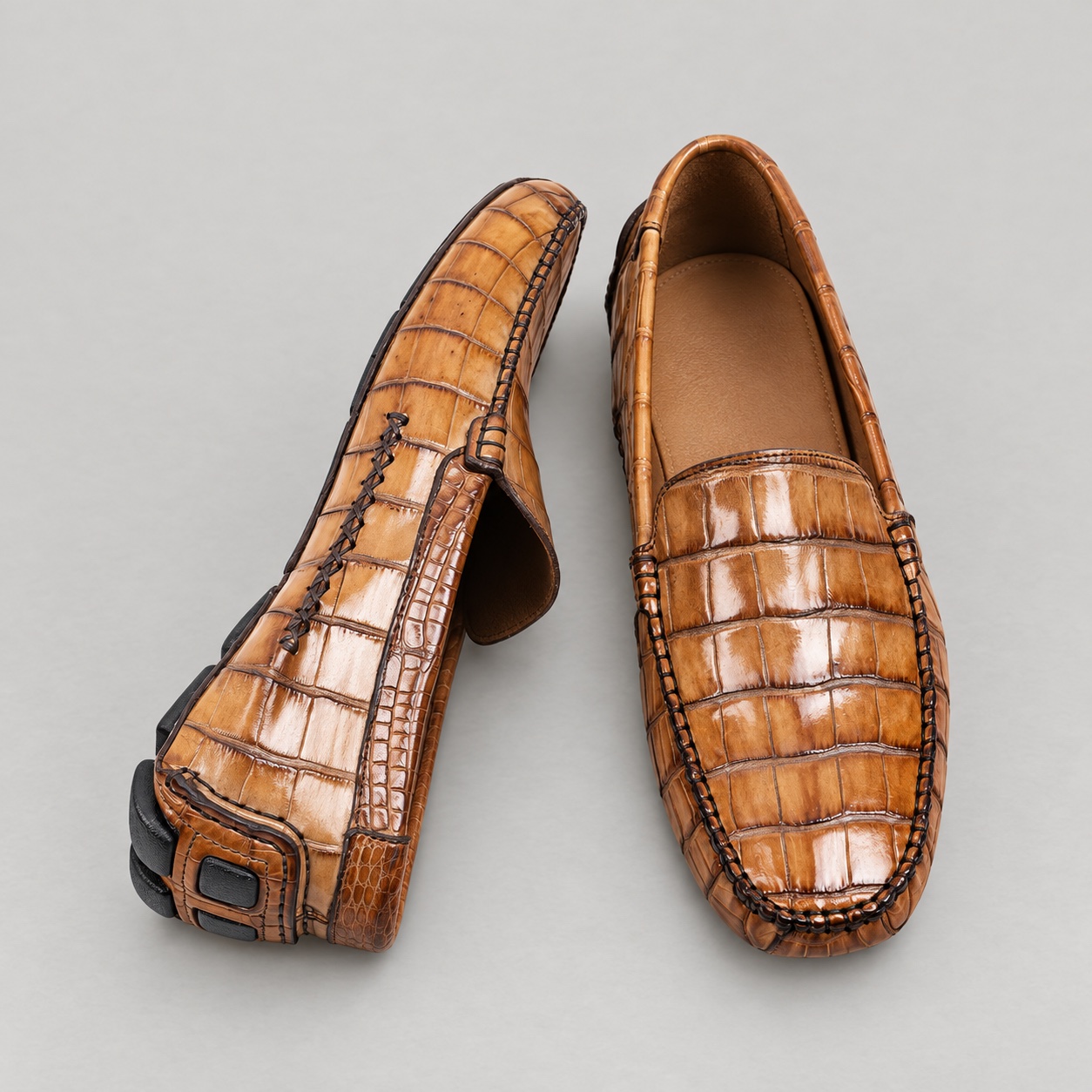 Top and heel views showing crocodile scales, dark moccasin stitching and unbranded tan lining