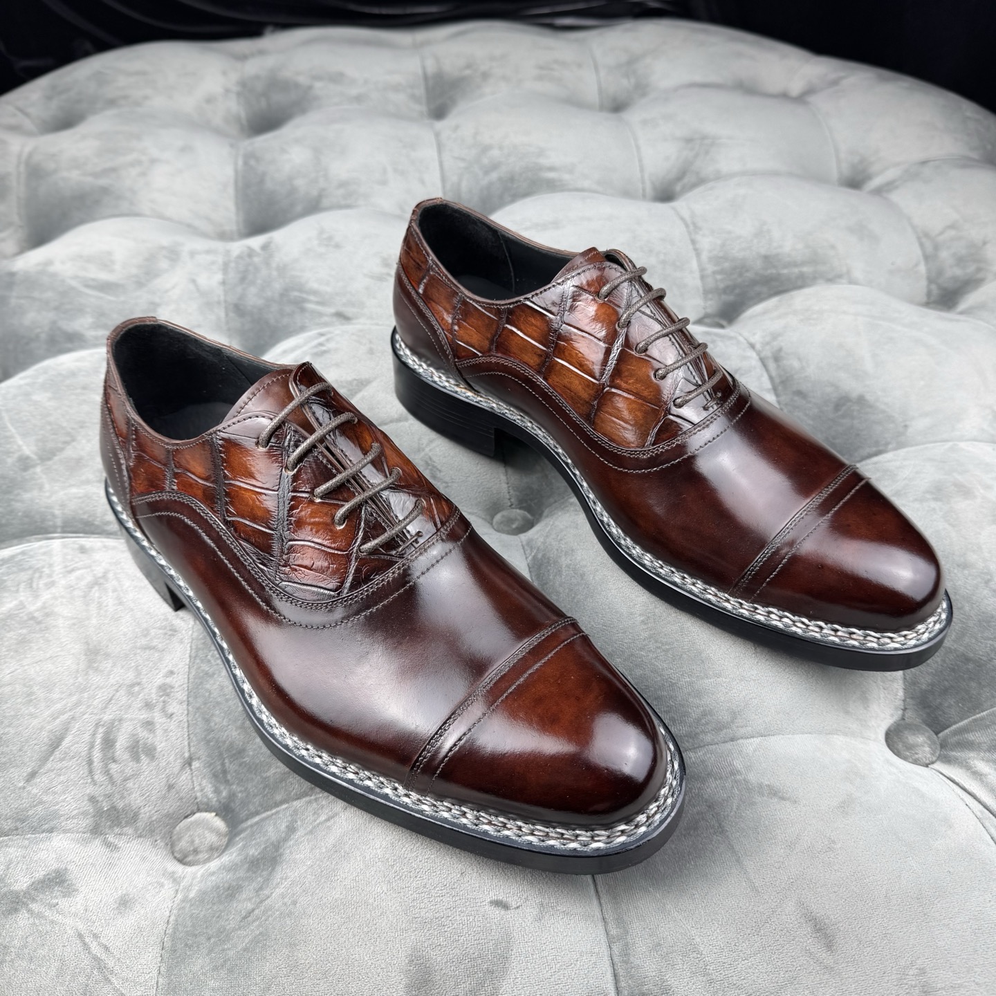 Pair of brown lace-up dress shoes with smooth toe panels and scale-patterned quarters